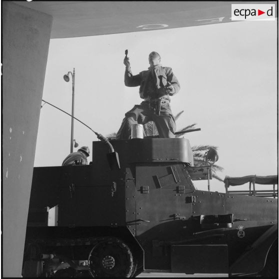 Oran. Mise en place des troupes sur les terrasses. Un soldat écrit "Vive De Gaulle" à la peinture, à l'entrée d'un immeuble.
