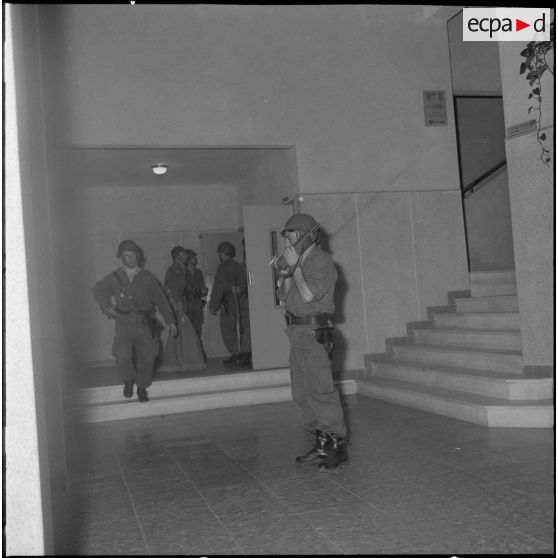 Oran. Mise en place des troupes sur les terrasses. Des soldats à l'intérieur d'un immeuble préparent des sacs.