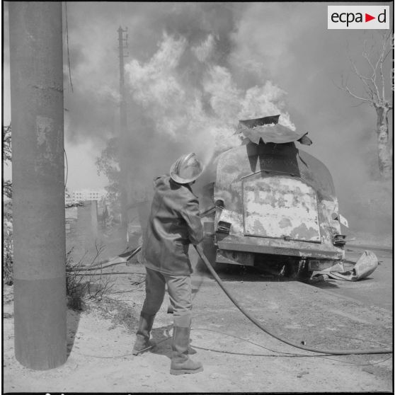 Alger. Quartier des Tagarins. Explosion d'un camion-citerne. Un pompier essaye d'éteindre l'incendie du camion-citerne.
