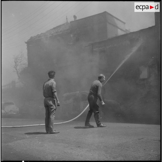 Alger. Quartier des Tagarins. Explosion d'un camion-citerne. Des civils essayent d'éteindre le feu à l'aide de la lance à incendie.