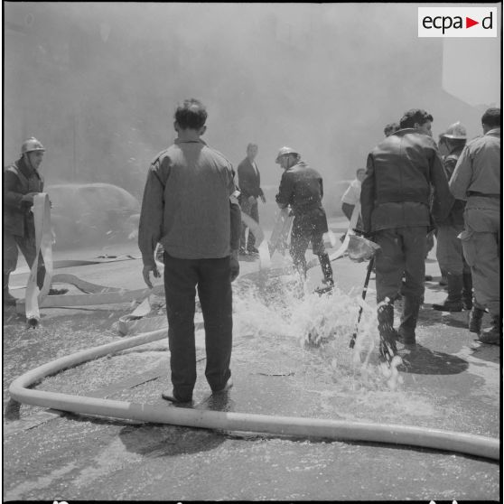 Alger. Quartier des Tagarins. Explosion d'un camion-citerne. Des civils aident les pompiers à installer la lance à incendie.