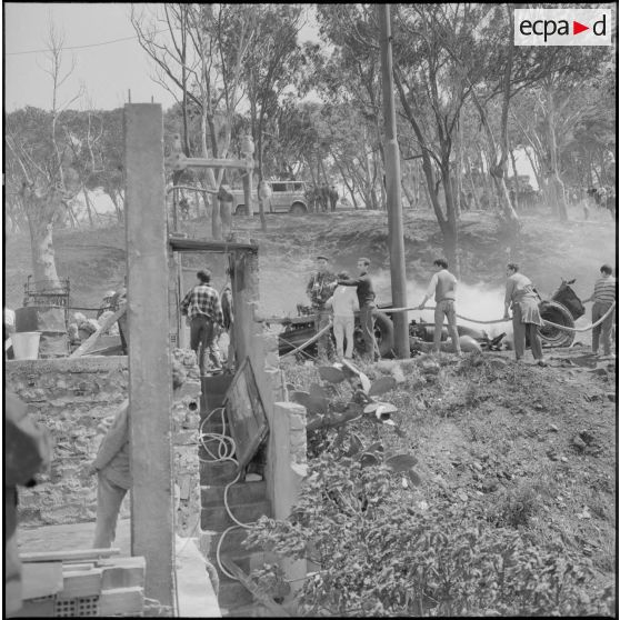 Alger. Quartier des Tagarins. Explosion d'un camion-citerne. Des civils aident les pompiers à installer la lance à incendie.