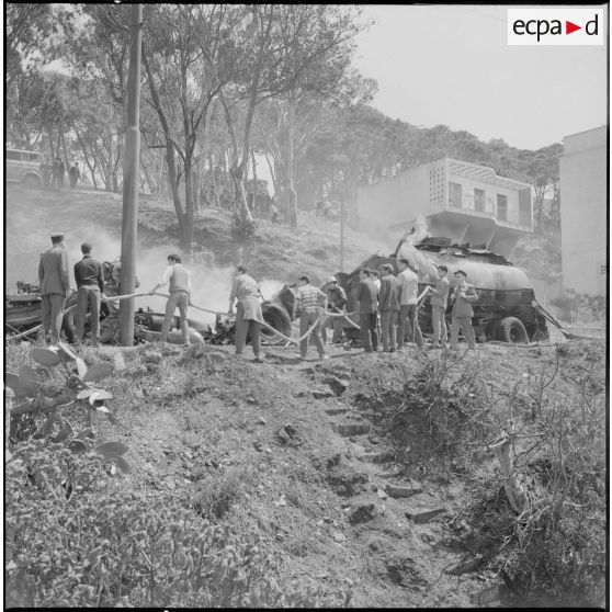 Alger. Quartier des Tagarins. Explosion d'un camion-citerne. Des civils aident les pompiers à installer la lance à incendie.