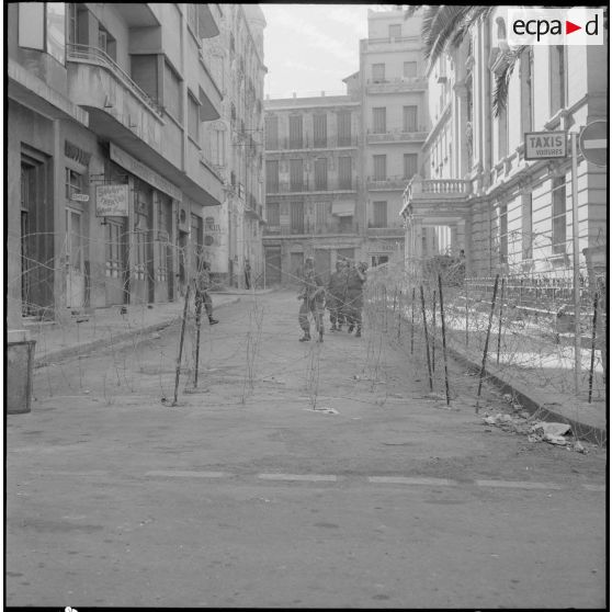 Oran. Suite d'une fusillade place Foch. Des soldats dans une rue bouclée.