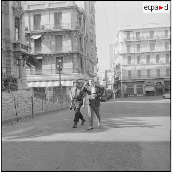 Oran. Suite d'une fusillade place Foch. Un homme montre quelquechose à un soldat.