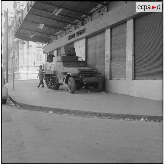 Oran. Suite d'une fusillade place Foch. Un half-track dans une rue.
