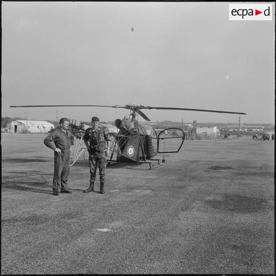 La Reghaïa. Pulvérisation de l'insecticide DDT (Dichloro-Diphenyl-Trichloroethane). Caméraman de l'Établissement cinématographique des armées (ECA) et pilote de l'hélicoptère alouette.