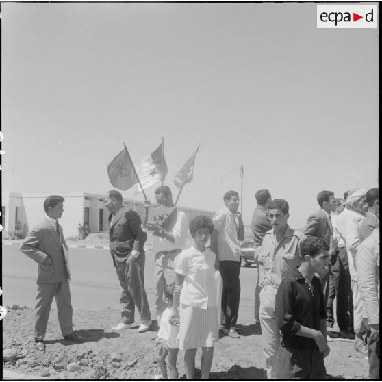 Des civils se préparent pour la cérémonie de lever des couleurs algériennes.