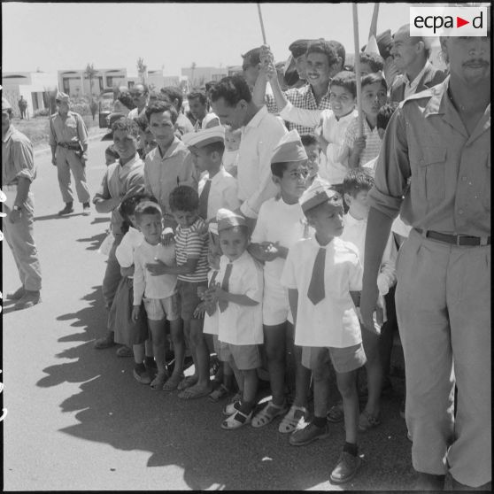 Des enfants parmi la foule attendent la cérémonie de lever des couleurs algériennes.