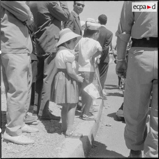 Des enfants parmi la foule attendent la cérémonie de lever des couleurs algériennes.