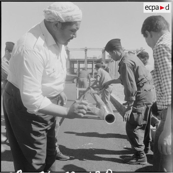 Préparation du poteau pour la cérémonie de lever des couleurs algériennes.