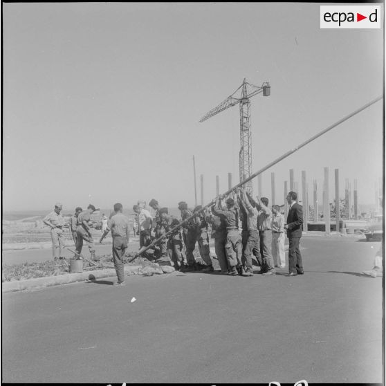 Préparation du poteau pour la cérémonie de lever des couleurs algériennes.
