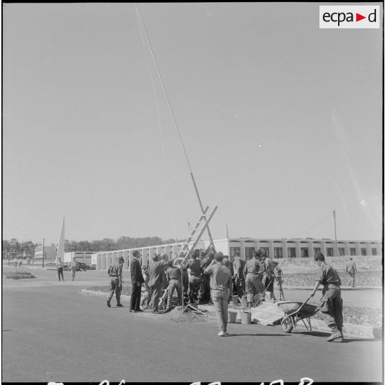 Préparation du poteau pour la cérémonie de lever des couleurs algériennes.