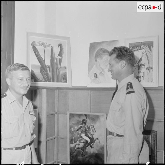 Des officiers visitent une exposition de peinture à la base aérienne 210 (BA 210).