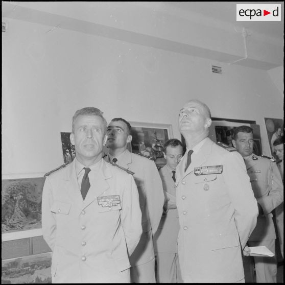 Des officiers visitent une exposition de peinture à la base aérienne 210 (BA 210).