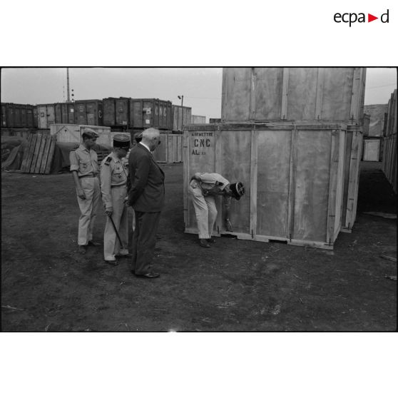 Un directeur de l'entreprise Danzas et Tailleur avec des militaires devant un container au port d'Oran.