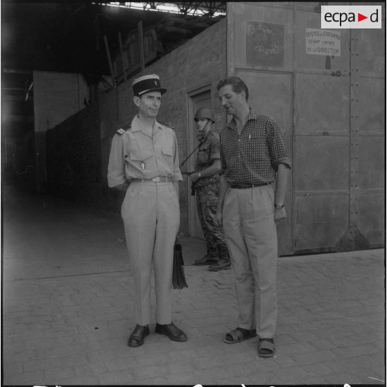 Un directeur de l'entreprise Danzas et Tailleur s'entretient avec un militaire sur le port d'Oran.