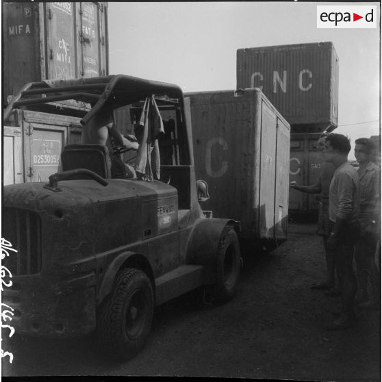 Chargement d'un container de l'entreprise Danzas et Tailleurs, à l'aide d'un Fenwick, au port d'Oran.