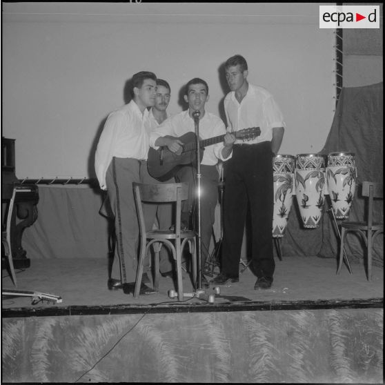 Groupe théâtral de Blida se produisant sur la scène du cinéma de La Reghaïa. Des chanteurs et un musicien.