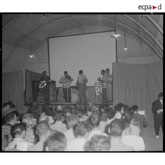 Groupe théâtral de Blida se produisant sur la scène du cinéma de La Reghaïa. Concert de musiciens sur scène.