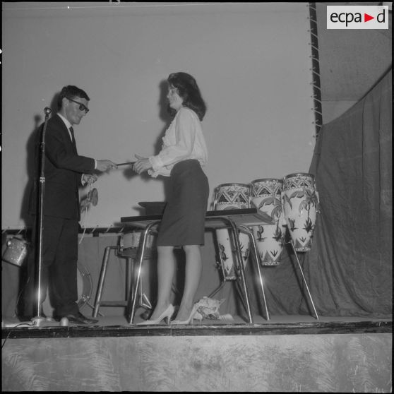 Groupe théâtral de Blida se produisant sur la scène du cinéma de La Reghaïa. Un comédien et une comédienne sur scène.
