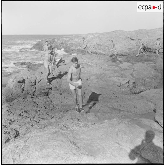 Activités sportives d'une section du 152e régiment d'infanterie (RI). Des soldats courent sur des rochers le long de la côte.