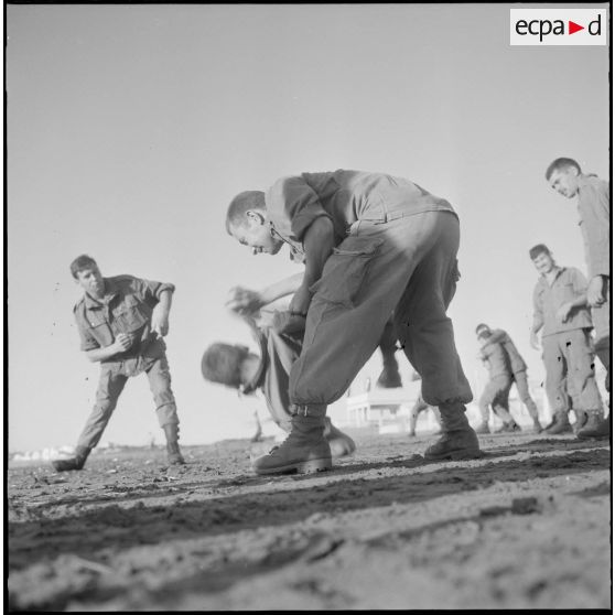 Activités sportives d'une section du 152e régiment d'infanterie (RI). Des soldats s'entraînent à la lutte sur une plage.