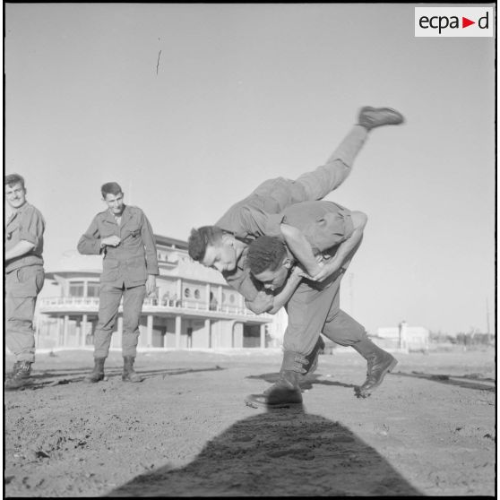 Activités sportives d'une section du 152e régiment d'infanterie (RI). Des soldats s'entraînent à la lutte sur une plage.