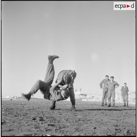 Activités sportives d'une section du 152e régiment d'infanterie (RI). Des soldats s'entraînent à la lutte sur une plage.