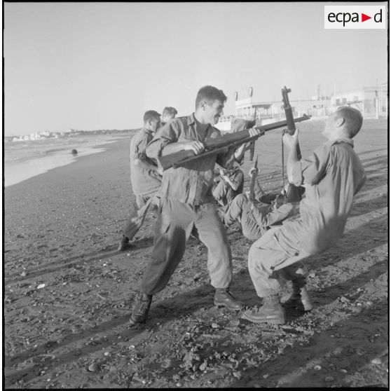 Entraînement d'une section du 152e régiment d'infanterie (RI) avec des fusils MAS 36 sur une plage.