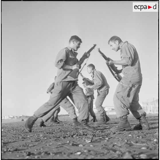 Entraînement d'une section du 152e régiment d'infanterie (RI) avec des fusils MAS 36 sur une plage.