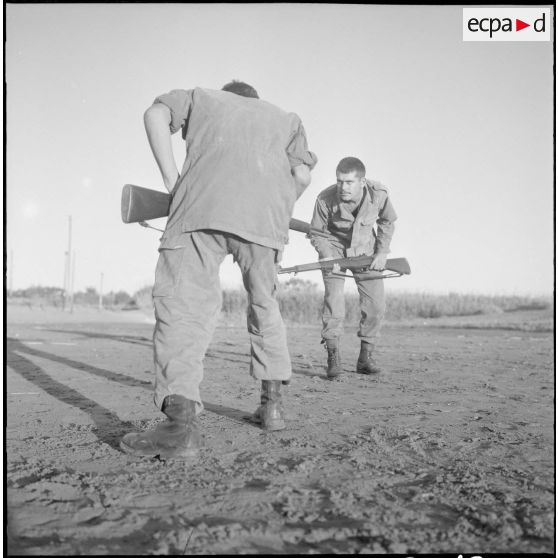 Entraînement d'une section du 152e régiment d'infanterie (RI) avec des fusils MAS 36 sur une plage.