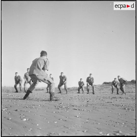 Activités sportives d'une section du 152e régiment d'infanterie (RI). Des soldats s'entraînent à la lutte sur une plage.