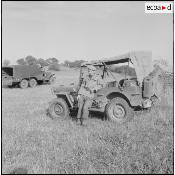 Portrait d'un soldat devant une jeep au 1er bataillon du 26ème régiment d'infanterie (RI) au camp des anglais.