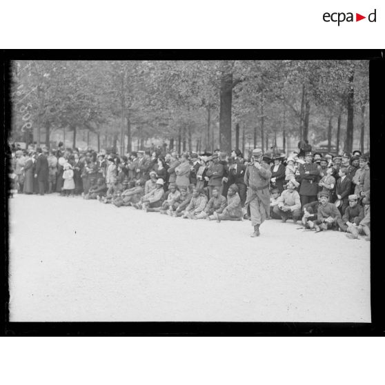 Remise de drapeaux aux Invalides aux régiments d'infanterie territoriale (230e-237e RIT). Un groupe de sénégalais dans la foule. [légende d'origine]