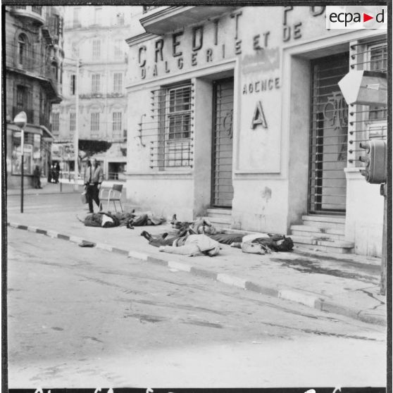 Alger. Fusillade au Plateau des Glières et rue d'Isly. Un civil passe à côté de civils tués étendus dans une rue.