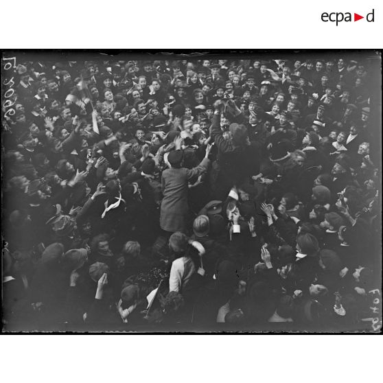 Lille, sur la grande place, la foule se dispute les journaux que lui donne un officier anglais. [légende d'origine]