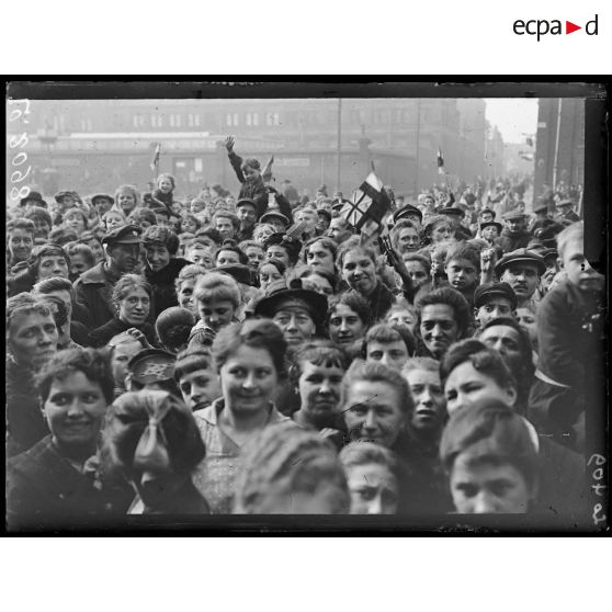 Lille, sur la grande place, la foule se dispute les journaux que lui donne un officier anglais. [légende d'origine]