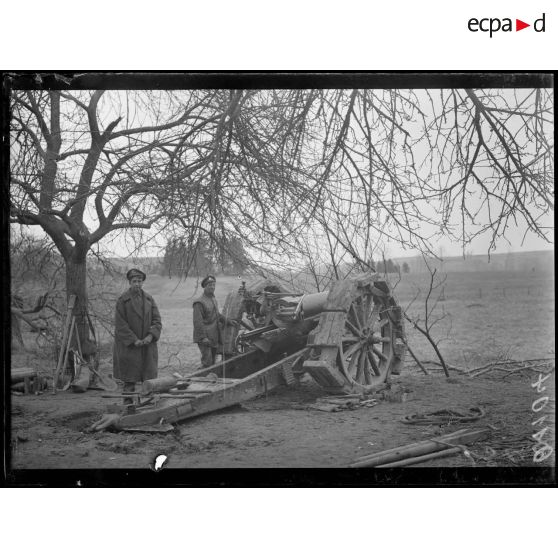 [Des soldats préparent le tir d'un canon de campagne.]