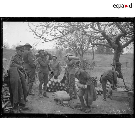 [Des soldats manient des obus sur un champ de tir.]