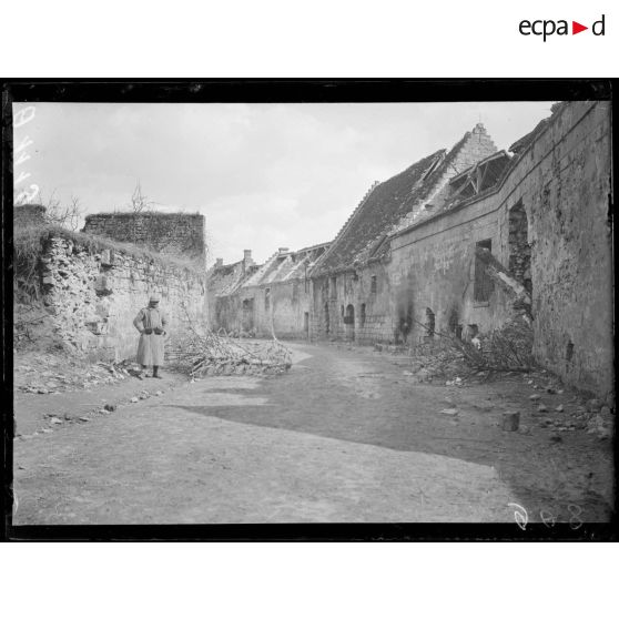 [Rue principale d'un village en ruines.]