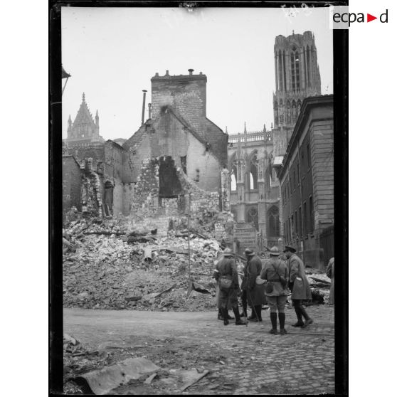 [Un groupe d'autorités militaires au milieu d'une ville en ruines.]