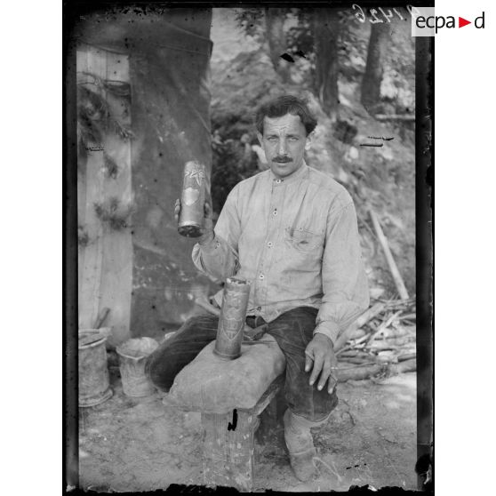 [Portrait d'un soldat qui tient une douille d'obus qu'il vient de sculpter et graver.]