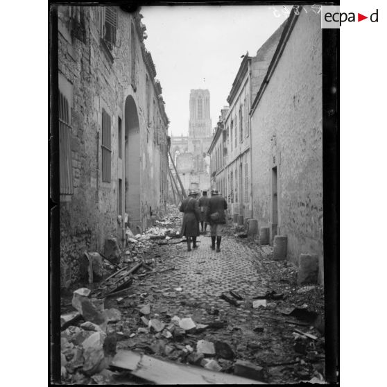 [A Amiens, un groupe de soldats se dirige vers la cathédrale à travers une rue en ruine.]