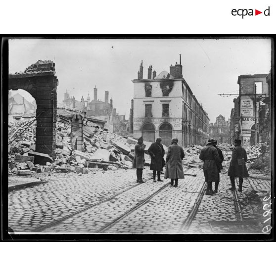 [Des autorités militaires procèdent à la reconnaissance de l'état de catastrophe causé par des bombardements, en centre ville d'Amiens.]