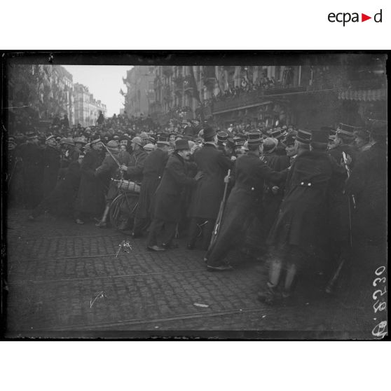 [La foule au passage des souverains belges, à Bruxelles, est retenue par les forces de l'ordre.]