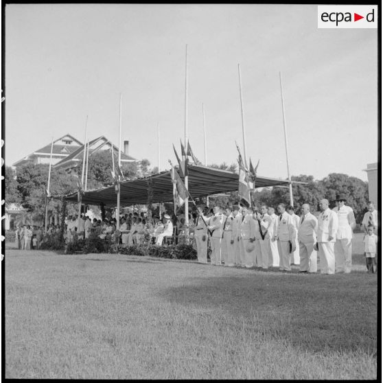 5 à 6 Le roi du Cambodge décore le fanion de sa garde personnelle. La tribune officielle et les drapeaux. [description provisoire]
