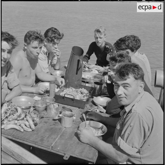 Un groupe de marins prend son repas à bord d'une vedette de patrouille (VP), lors d'une opération de surveillance des Lacs. [description provisoire]
