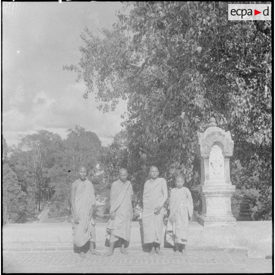 Photographies de groupe de jeunes bonzes posant devant des statues. [description provisoire]