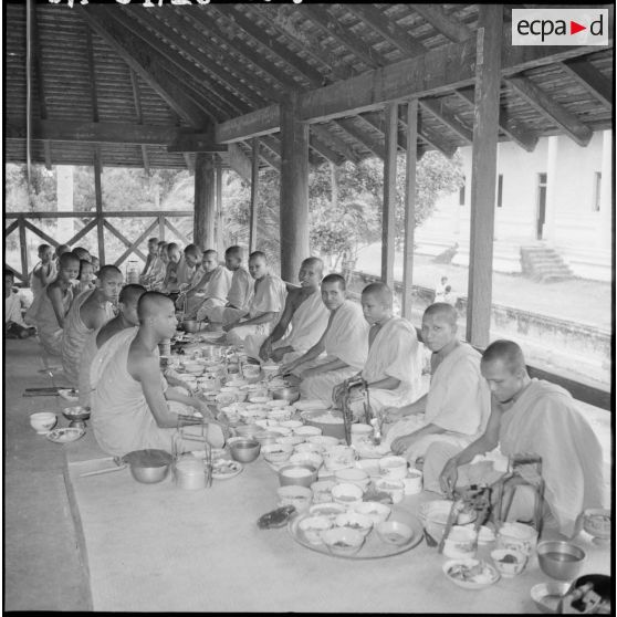 Repas rituel des bonzes dans la salle des fêtes auquel assistent les fidèles. [description provisoire]